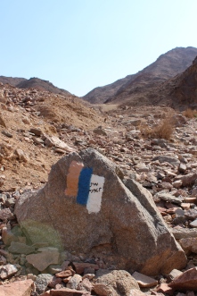 Israel National Trail marker near Eilat. The National trail runs from the Israel-Lebanon border to the Red Sea. The orange stripe represents the desert (South), and the white stripe represents snow (North). Since the orange stripe is on top, you know you're hiking south. Israel does a REALLY good job marking ALL their hiking trails.